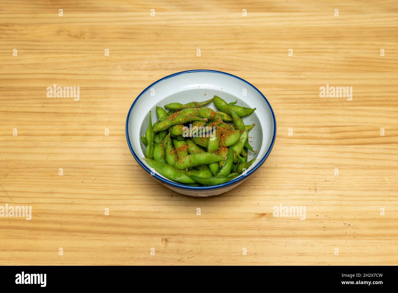 Ciotola di edamame in cialde cosparse di spezie calde Foto Stock