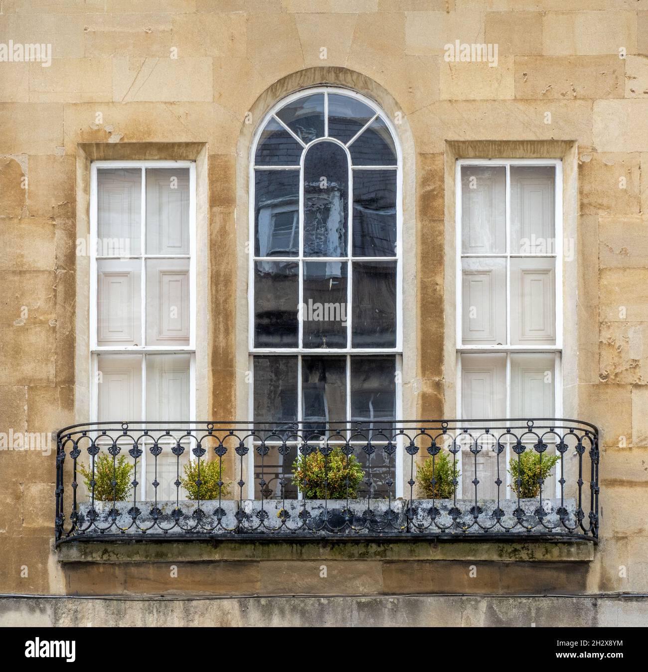 Elegante finestra georgiana a tre ante con finestra centrale ad arco frontata da un balcone in ferro battuto - Bath Somerset UK Foto Stock