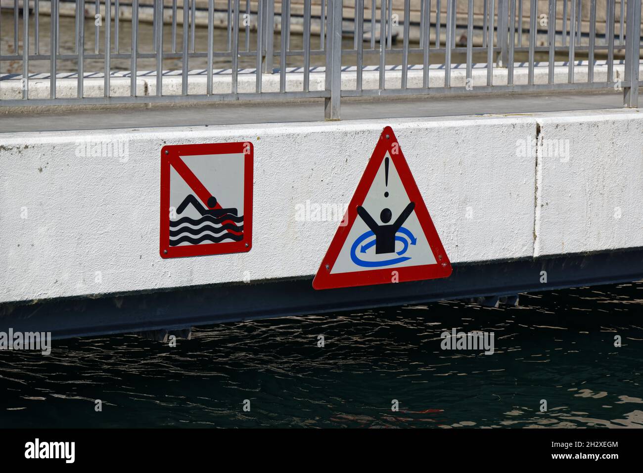no nuoto e attenzione water vortex divieto segni su un ponte bianco, il nuoto è vietato e vi è un avvertimento di annegamento improvviso da acqua vo Foto Stock