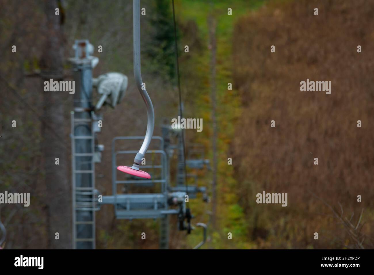 Primo piano di uno skilift con una punta in plastica rosa in un paesaggio autunnale Foto Stock