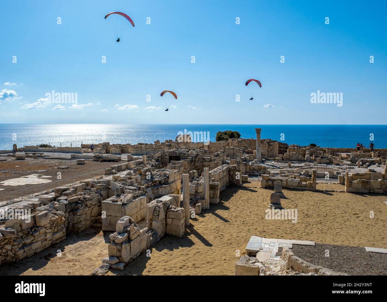 I parapendio scivolano sulle rovine della Basilica cristiana presso il sito archeologico di Kourion, Cipro. Foto Stock