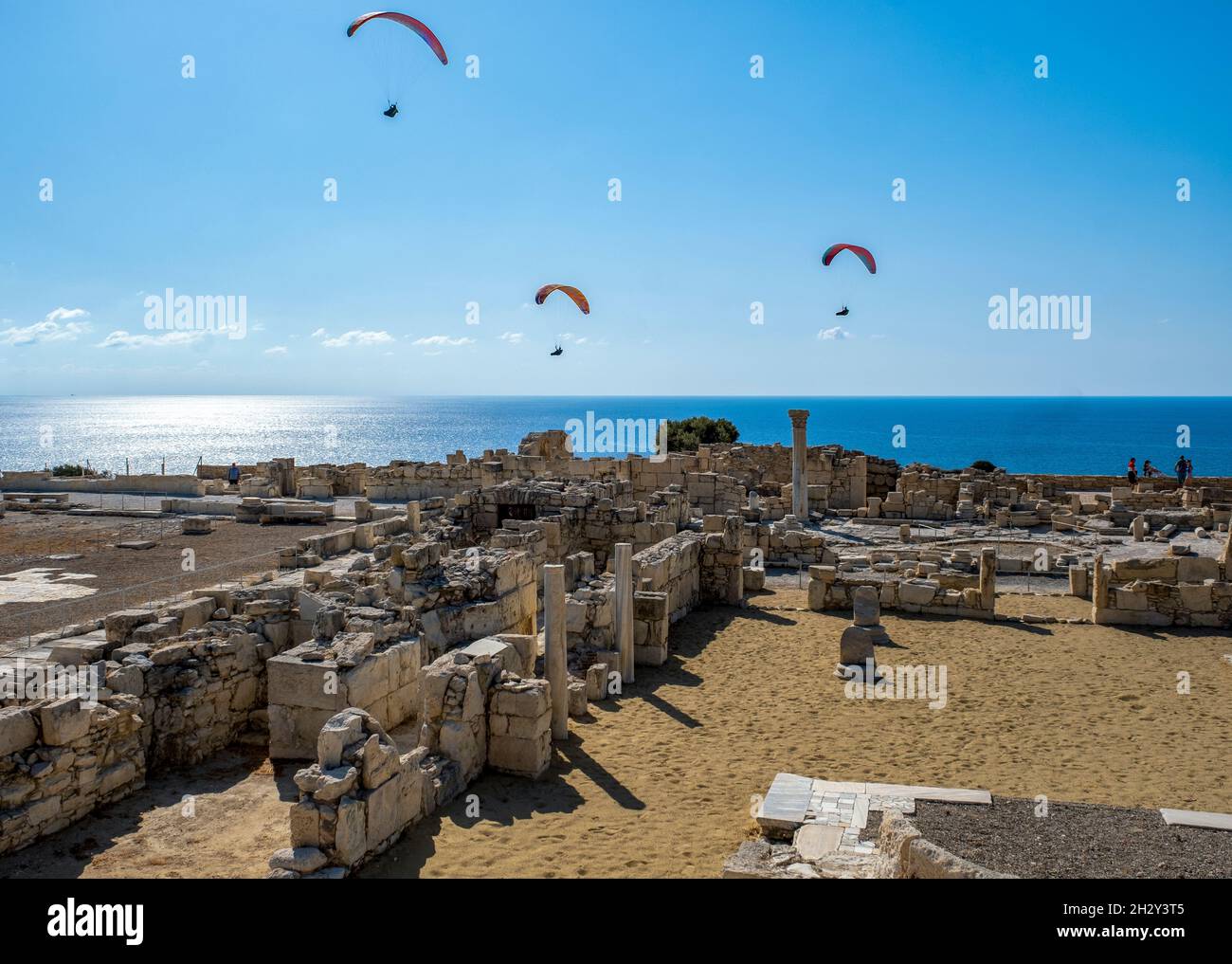 I parapendio scivolano sulle rovine della Basilica cristiana presso il sito archeologico di Kourion, Cipro. Foto Stock