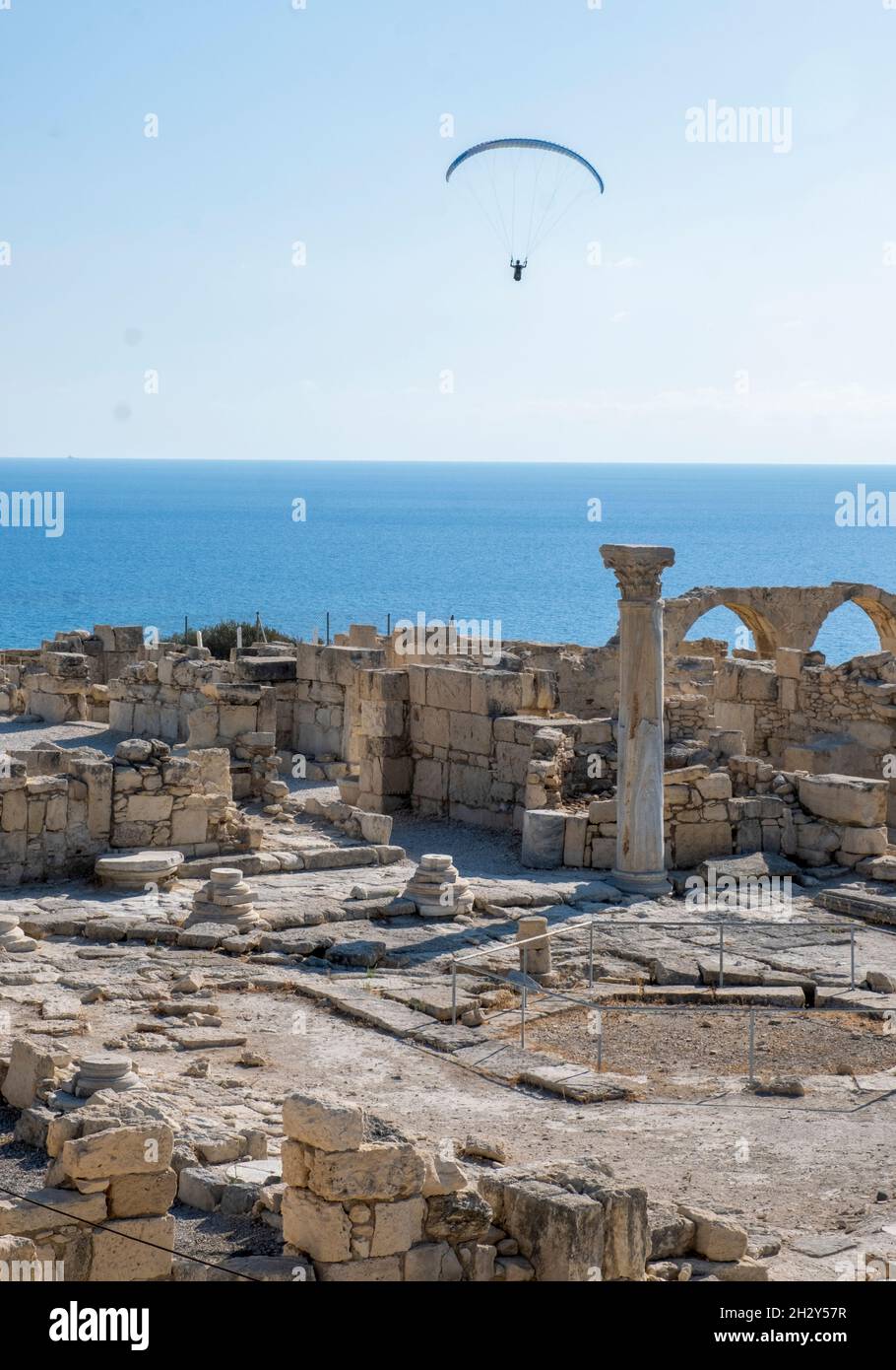 Il parapendio scivola sulle rovine della Basilica cristiana presso il sito archeologico di Kourion, Cipro. Foto Stock