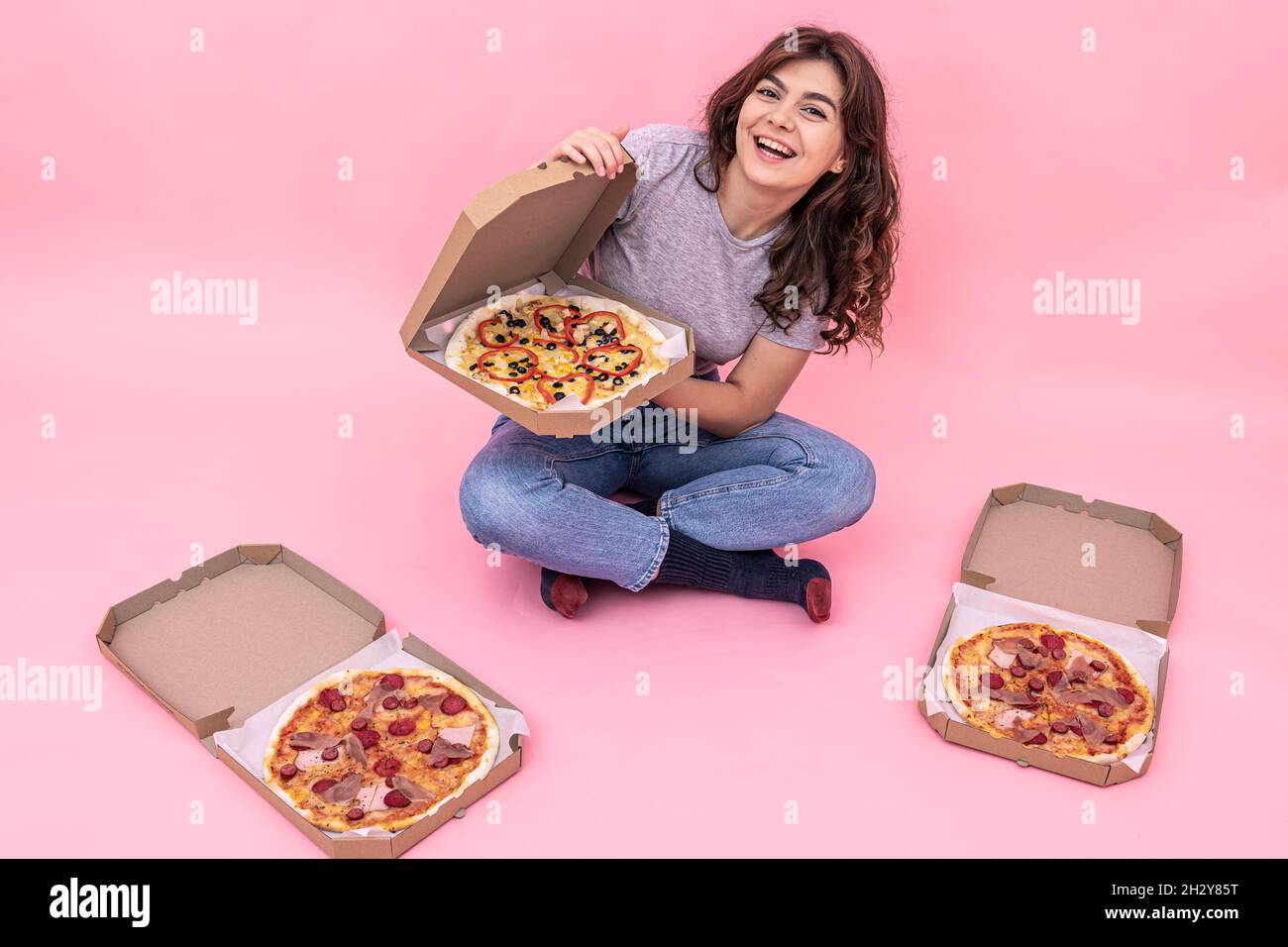 Ragazza attraente con pizza da scatole per la consegna su uno sfondo rosa  Foto stock - Alamy