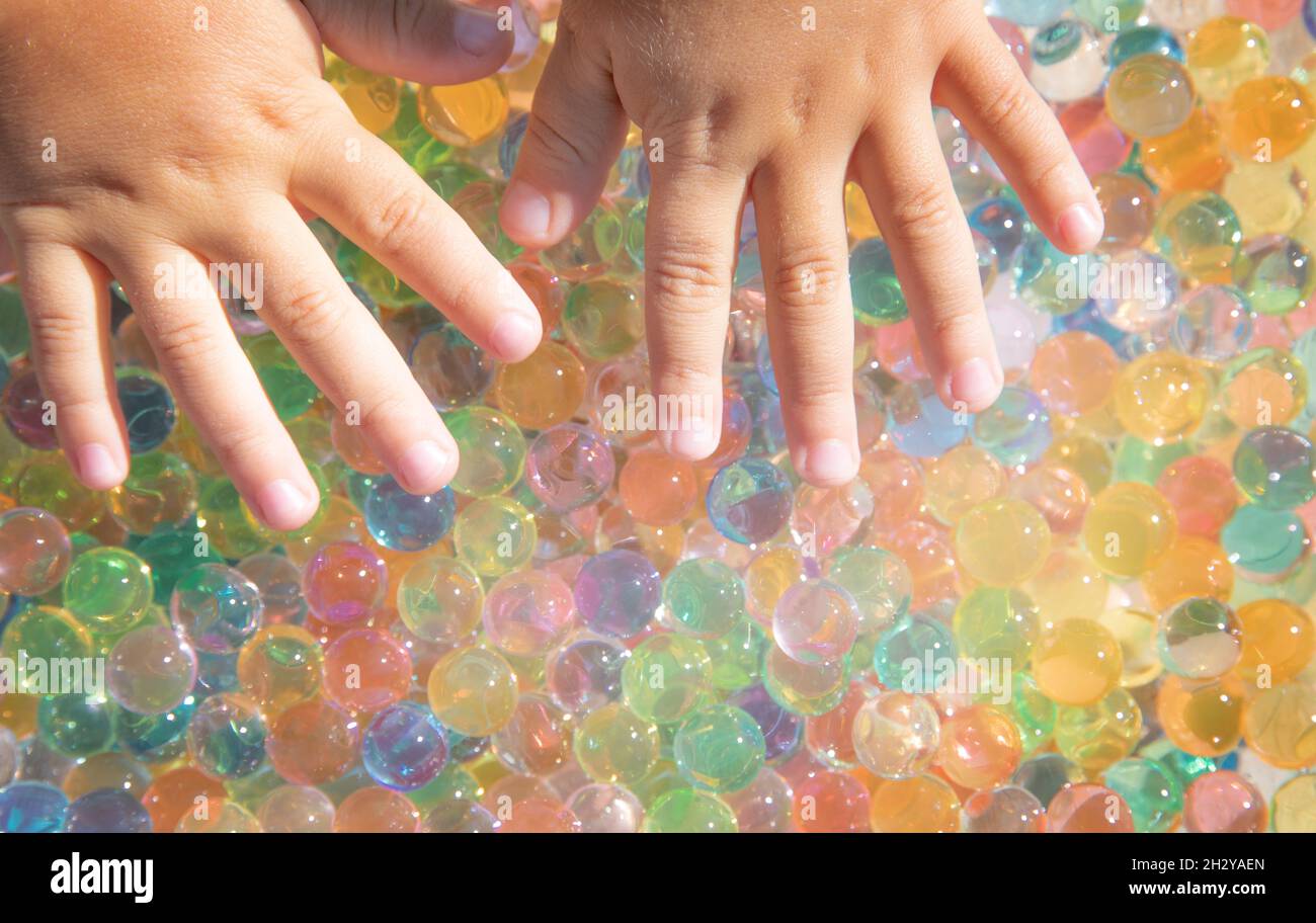 Sfere colorate di idrogel toccano le mani dei bambini. Sensazioni sensoriali. Foto Stock