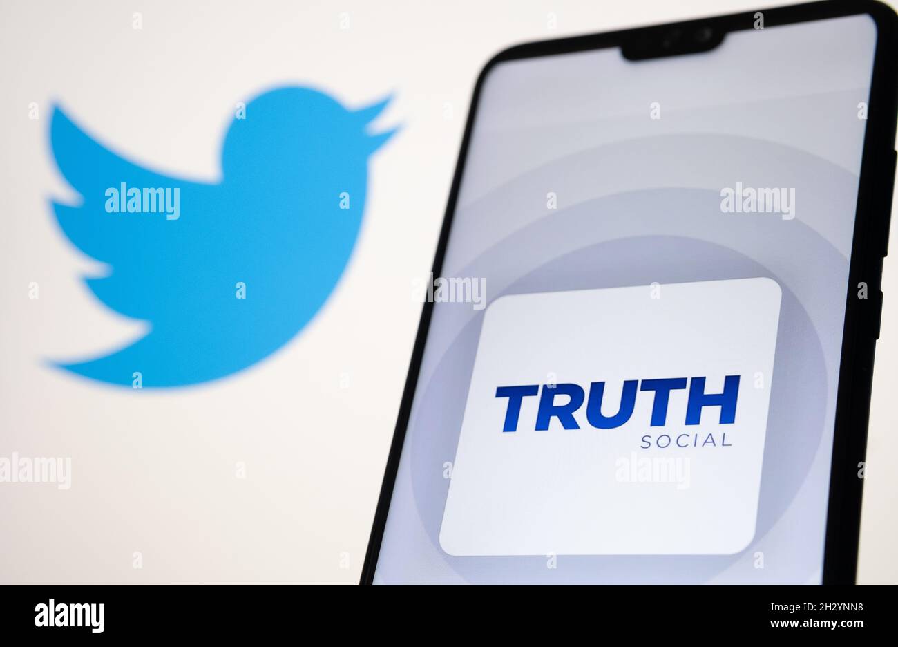 Il logo dell'app sociale di verità è visibile sullo smartphone con il logo Twitter sfocato sullo sfondo. Nuova piattaforma di social media di Donald Trump. Stafford, Unite Foto Stock