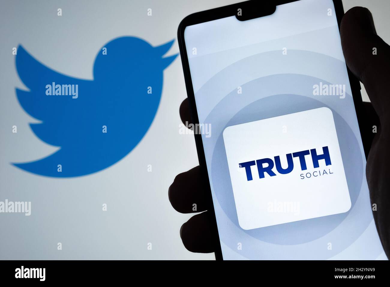 Il logo dell'app sociale di verità è visibile sullo smartphone con il logo Twitter sfocato sullo sfondo. Nuova piattaforma di social media di Donald Trump. Stafford, Unite Foto Stock
