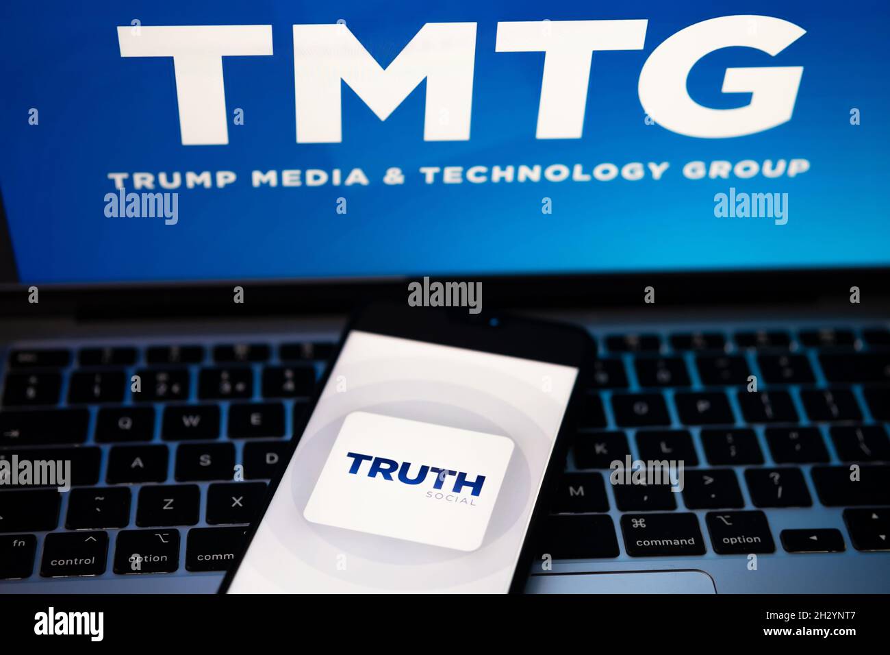 Il logo dell'app sociale verità è visibile sullo smartphone e il logo TMTG è sfocato sul laptop. Nuova piattaforma di social media di Donald Trump. Stafford, Regno Unito Foto Stock