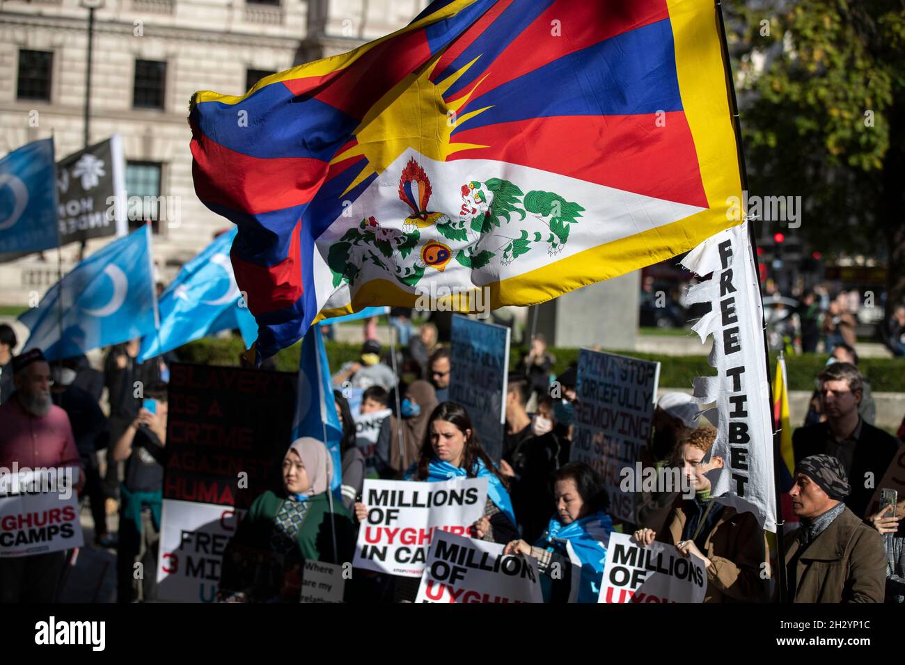 Londra, Regno Unito. 24 ottobre 2021. I manifestanti detengono bandiere e cartelli che esprimono le loro opinioni durante la manifestazione.Un raduno organizzato da sei diversi gruppi di diritti umani di Uyghur, Tibet e Hong Kong che chiedono “dire no alle Olimpiadi invernali di Pechino, dire no al genocidio”, che si è collegato a tre obiettivi fondamentali: "Protesta contro le Olimpiadi invernali di Pechino del 2022", "Uyghurs, tibetani e popolo di Hong Kong" e "consegnare una torcia relè per interpretare lo spirito olimpico". Credit: SOPA Images Limited/Alamy Live News Foto Stock