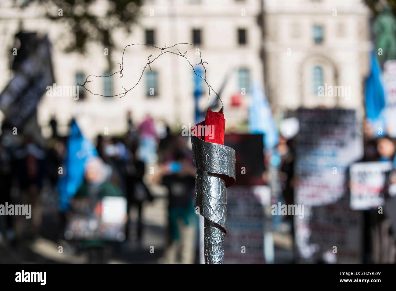 Londra, Regno Unito. 24 ottobre 2021. Durante la dimostrazione si vede una replica di torcia olimpica.Un raduno organizzato da sei diversi gruppi di diritti umani da Uyghur, Tibet e Hong Kong che chiedono “dire no alle Olimpiadi invernali di Pechino, dire no al genocidio” che hanno collegato con tre obiettivi fondamentali: "Protesta contro le Olimpiadi invernali di Pechino del 2022", "Uyghurs, tibetani e popolo di Hong Kong" e "consegnare una torcia relè per interpretare lo spirito olimpico". (Photo by May James/SOPA Images/Sipa USA) Credit: Sipa USA/Alamy Live News Foto Stock