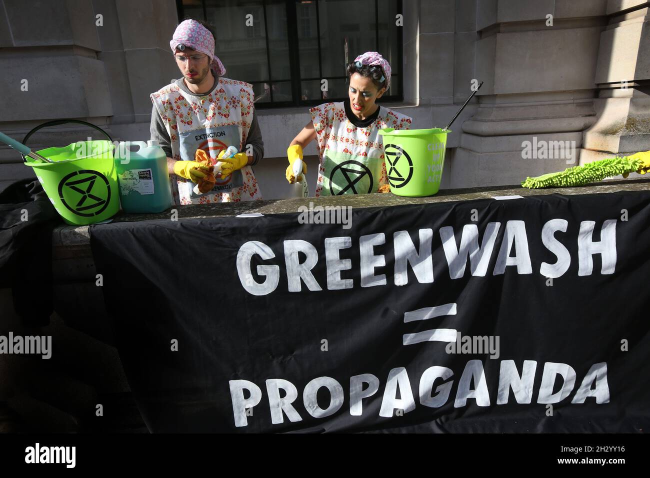 Londra, Regno Unito. 24 ottobre 2021. Gli scrubbers hanno un banner che legge 'Greenwash=propaganda durante una protesta al di fuori del Museo della Scienza.la ribellione dell'estinzione insistono che il Museo della Scienza smetta di ricevere la sponsorizzazione da multinazionali del petrolio e del gas come Shell e BP. Accettando la sponsorizzazione di alcuni dei più grandi inquinatori del mondo, i prestigiosi musei li stanno aiutando a ripulire la loro immagine e a continuare la loro devastante distruzione planetaria. Credit: SOPA Images Limited/Alamy Live News Foto Stock