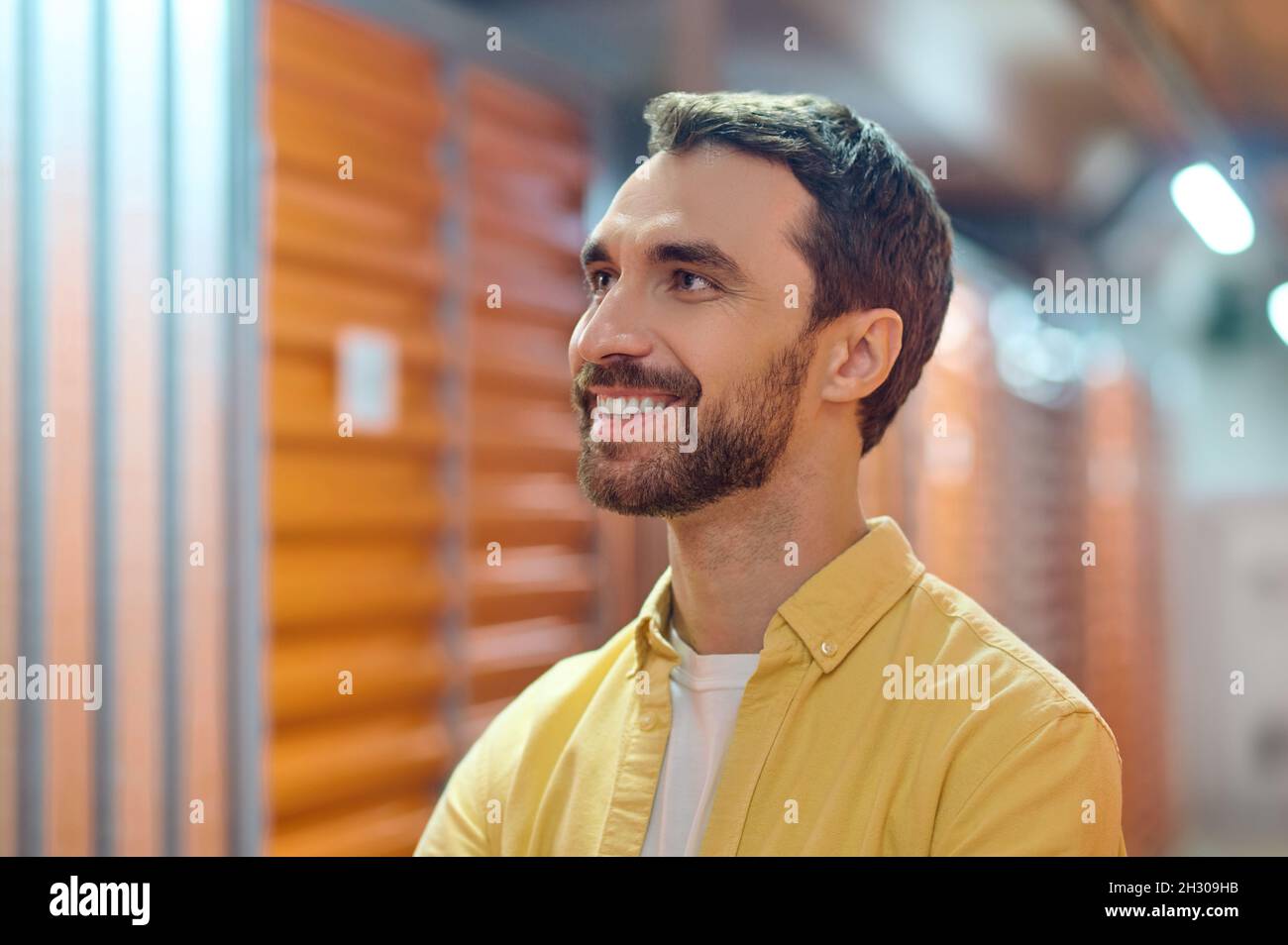 Uomo gioioso che guarda su e a fianco Foto Stock