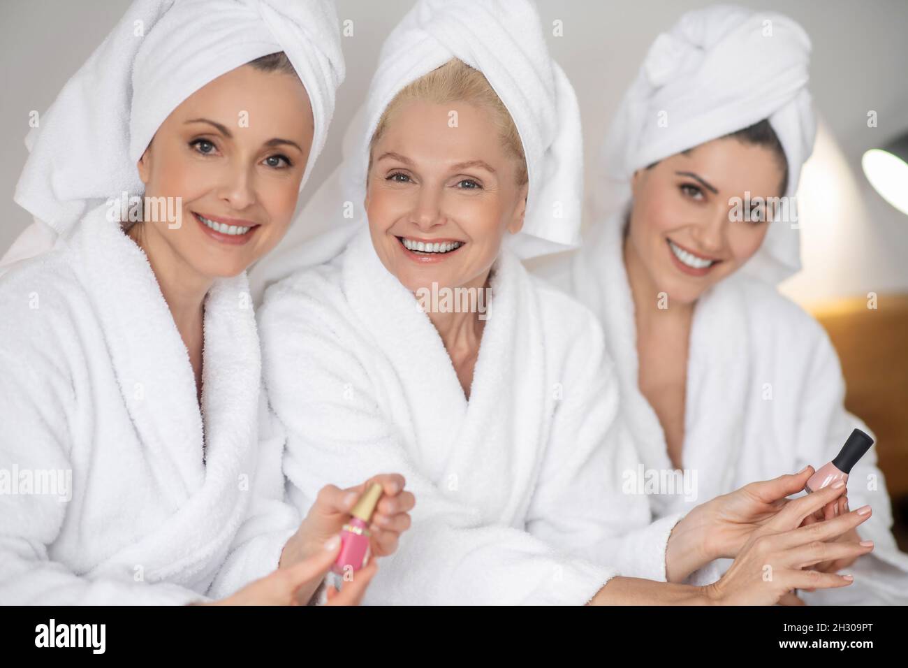 Tre belle donne che raccolgono smalto unghie Foto Stock