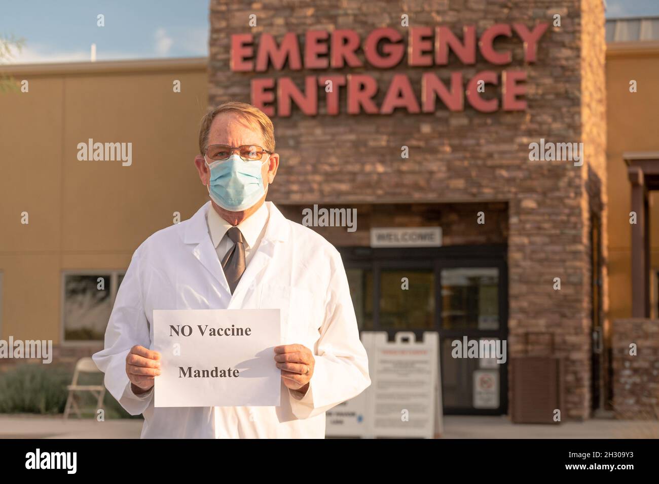 IL medico DELL'ER detiene il segno Nessun mandato vaccinale di fronte all'ingresso dell'ospedale Foto Stock