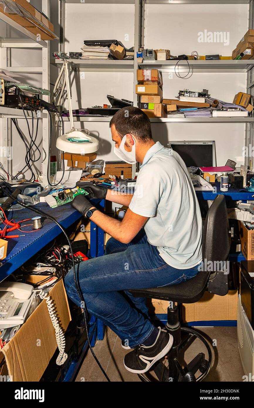 Tecnico informatico che lavora in officina Foto Stock