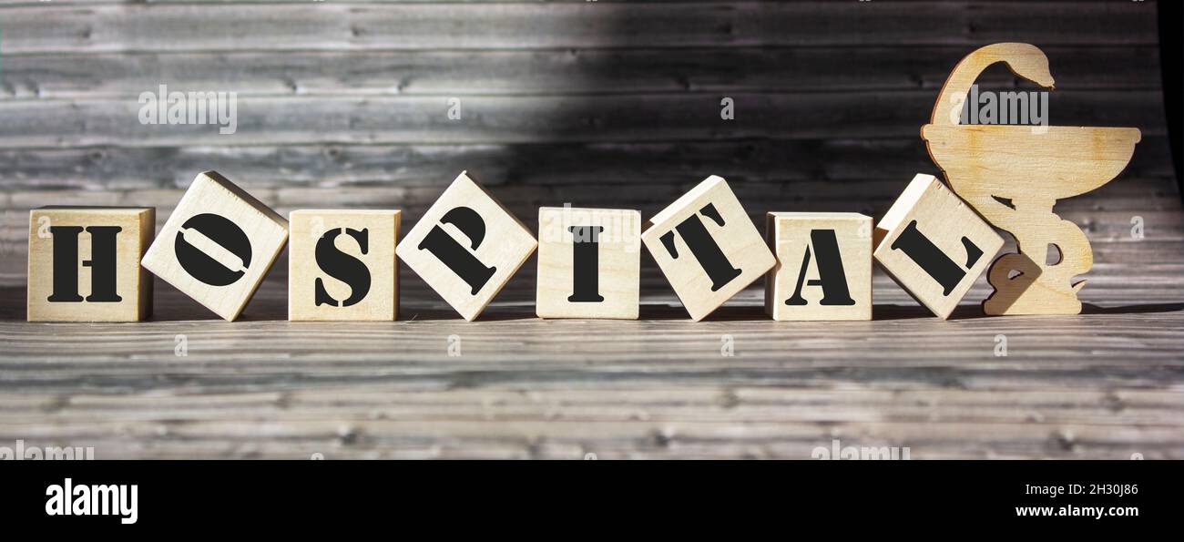 La parola ospedale è scritta su un blocco di legno. Concetto di medicina Foto Stock