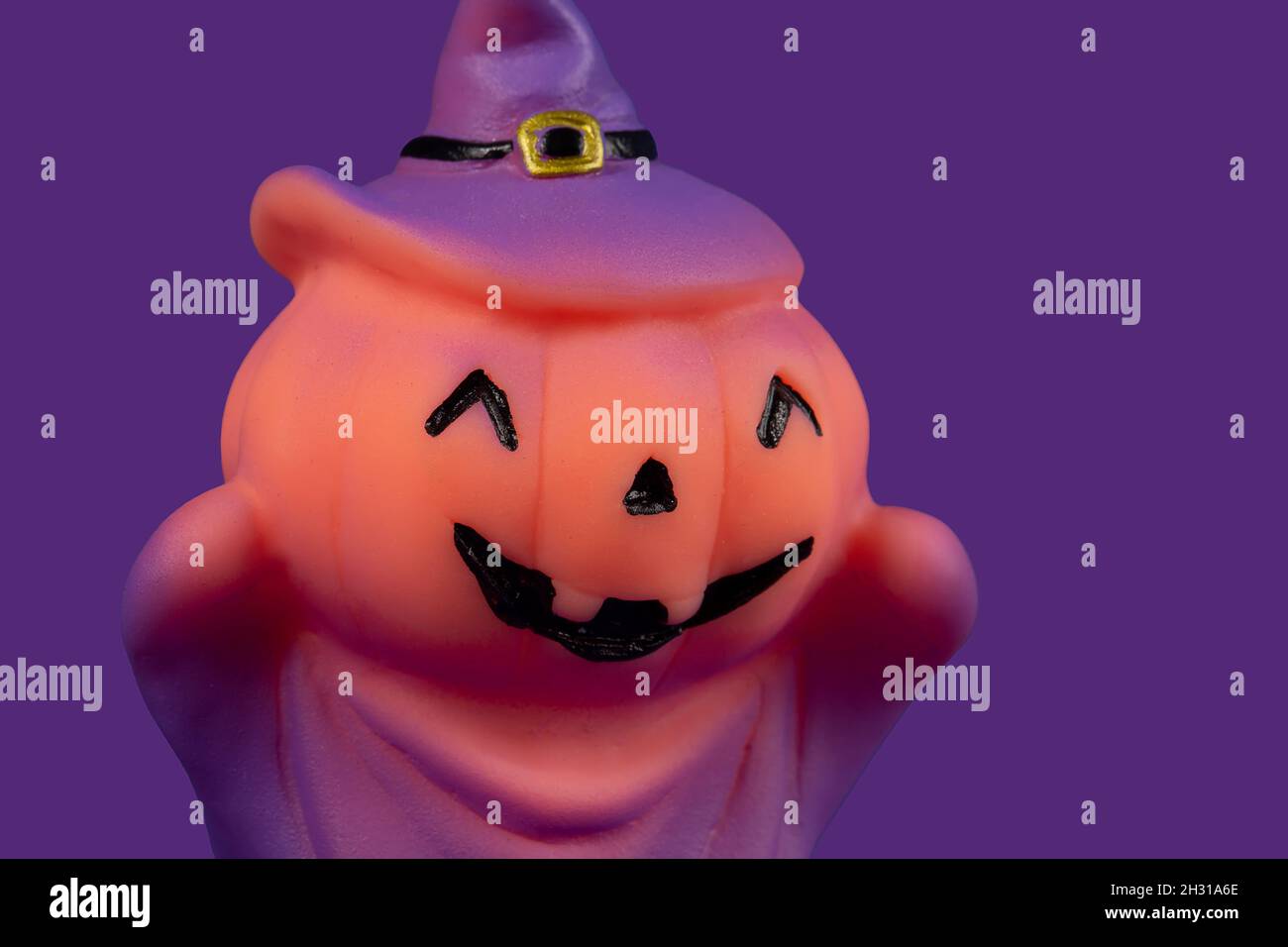 Bambola strega di zucca di Halloween su sfondo viola. Foto Stock