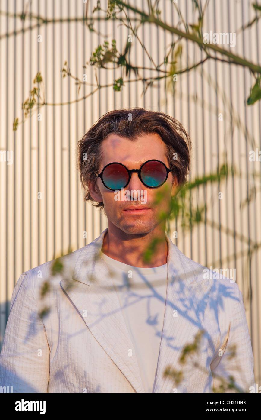Primo piano ritratto di un bell'uomo con occhiali da sole hippie rotondi  Foto stock - Alamy