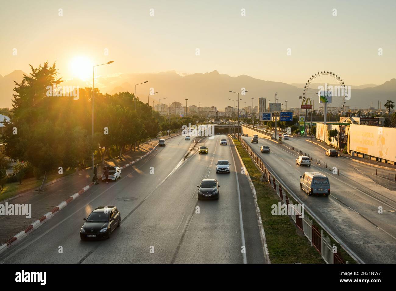 Strada trafficata nella città di Antalya al tramonto, Turchia Foto Stock