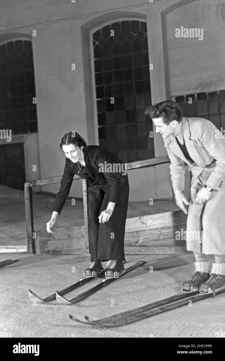 Ein Skilehrer beim Unterricht mit Anfängerin sci in einer Skihalle, Deutschland 1930er Jahre. Un maestro di sci ad una lezione con una femmina di sci principiante, Germania 1930s. Foto Stock