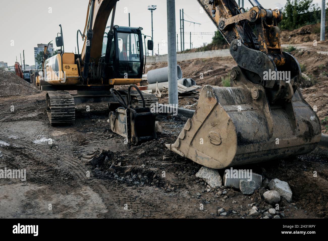 Escavatore in cantiere. Retroescavatore su lavori di fondazione e costruzione di strade. Macchinari pesanti e attrezzature da costruzione Foto Stock