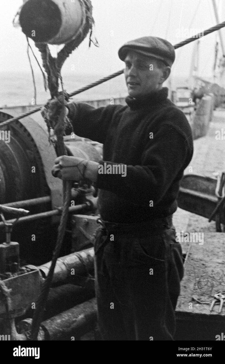 Mann der Besatzung des Fabrikschiffes 'Jan Wellem' der deutschen Walfangflotte bei er Arbeit un mazzo, 1930er Jahre. Membro dell equipaggio della nave officina 'Jan Wellem' del tedesco flotta baleniera al lavoro sul ponte, 1930s. Foto Stock