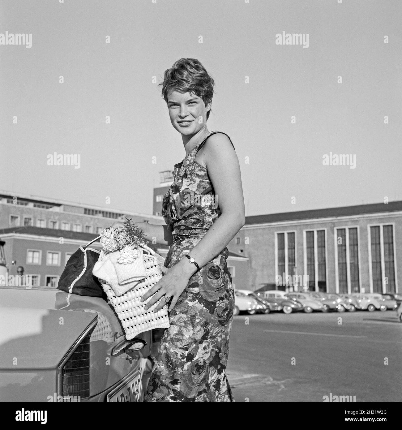Eine junge Frau posiert an einem Auto, Deutschland 1959. Una giovane donna in piedi da un'auto, Germania 1959. Foto Stock