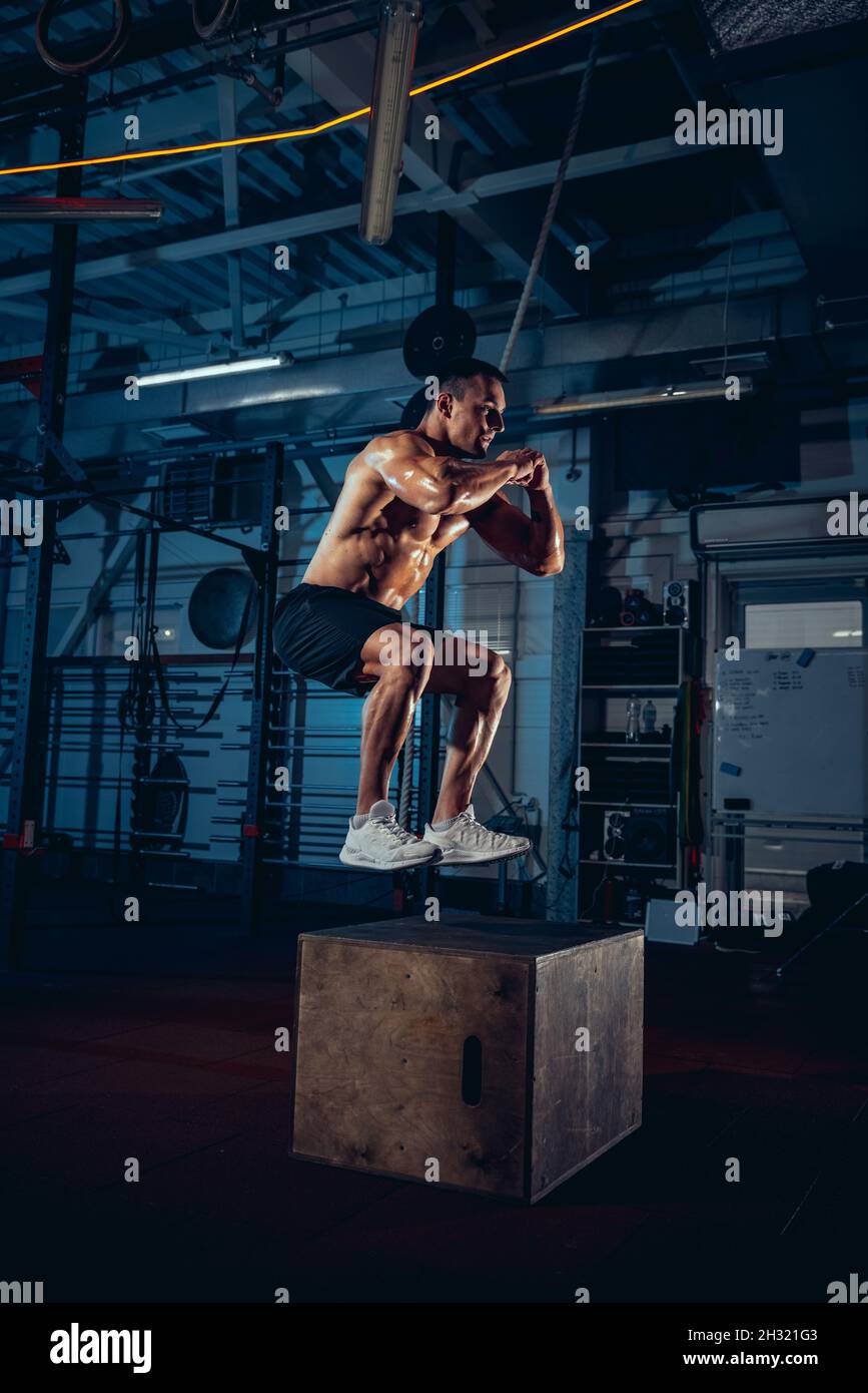 Ritratto di uomo sportivo, allenamenti bodybuilder in palestra sportiva, al chiuso. Concetto di sport, attività, stile di vita sano Foto Stock