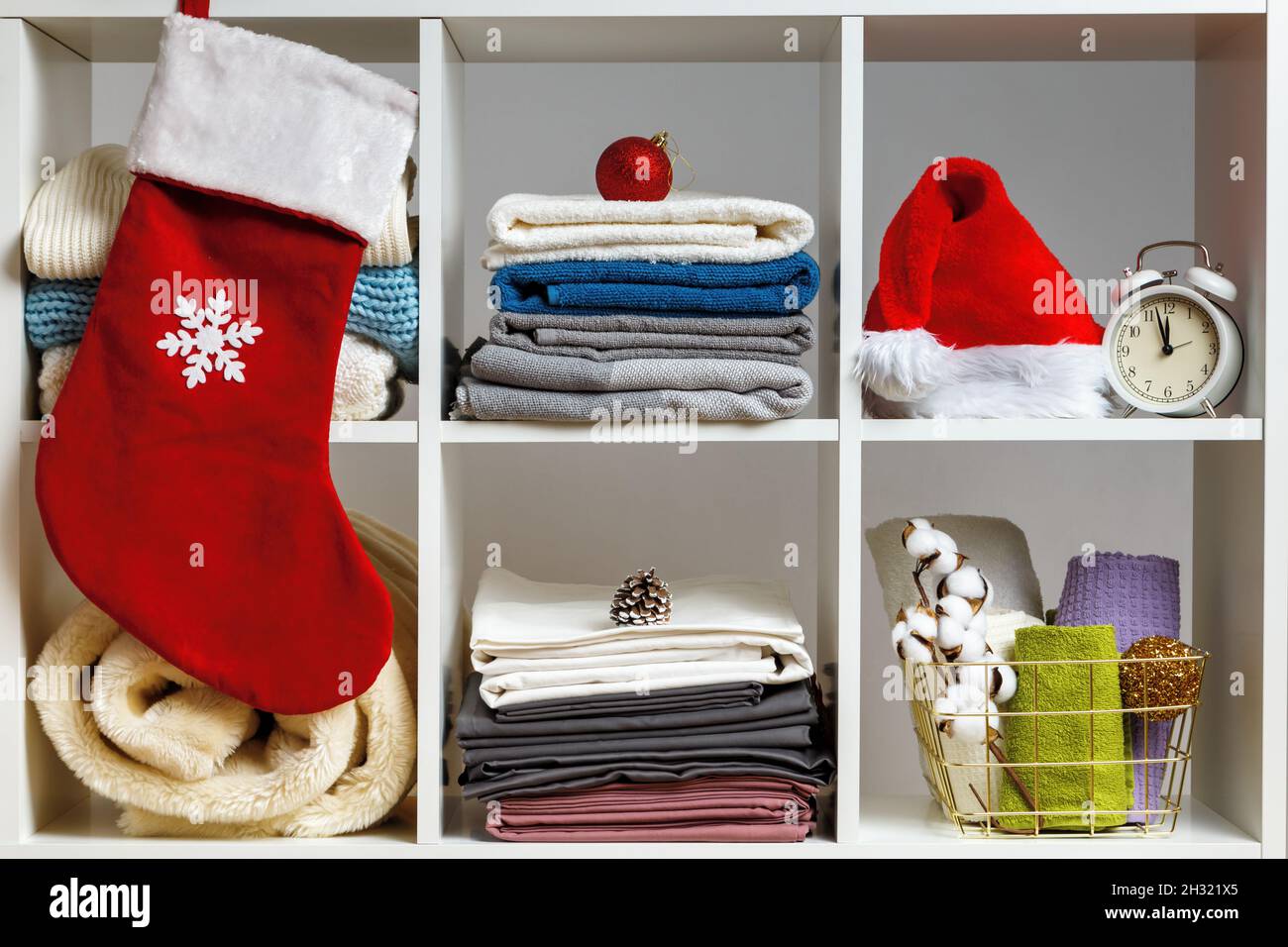 Organizzazione dello storage. Biancheria da letto, asciugamani, lenzuola, coperte sugli scaffali sono decorati per la celebrazione del Natale e Capodanno. Foto Stock