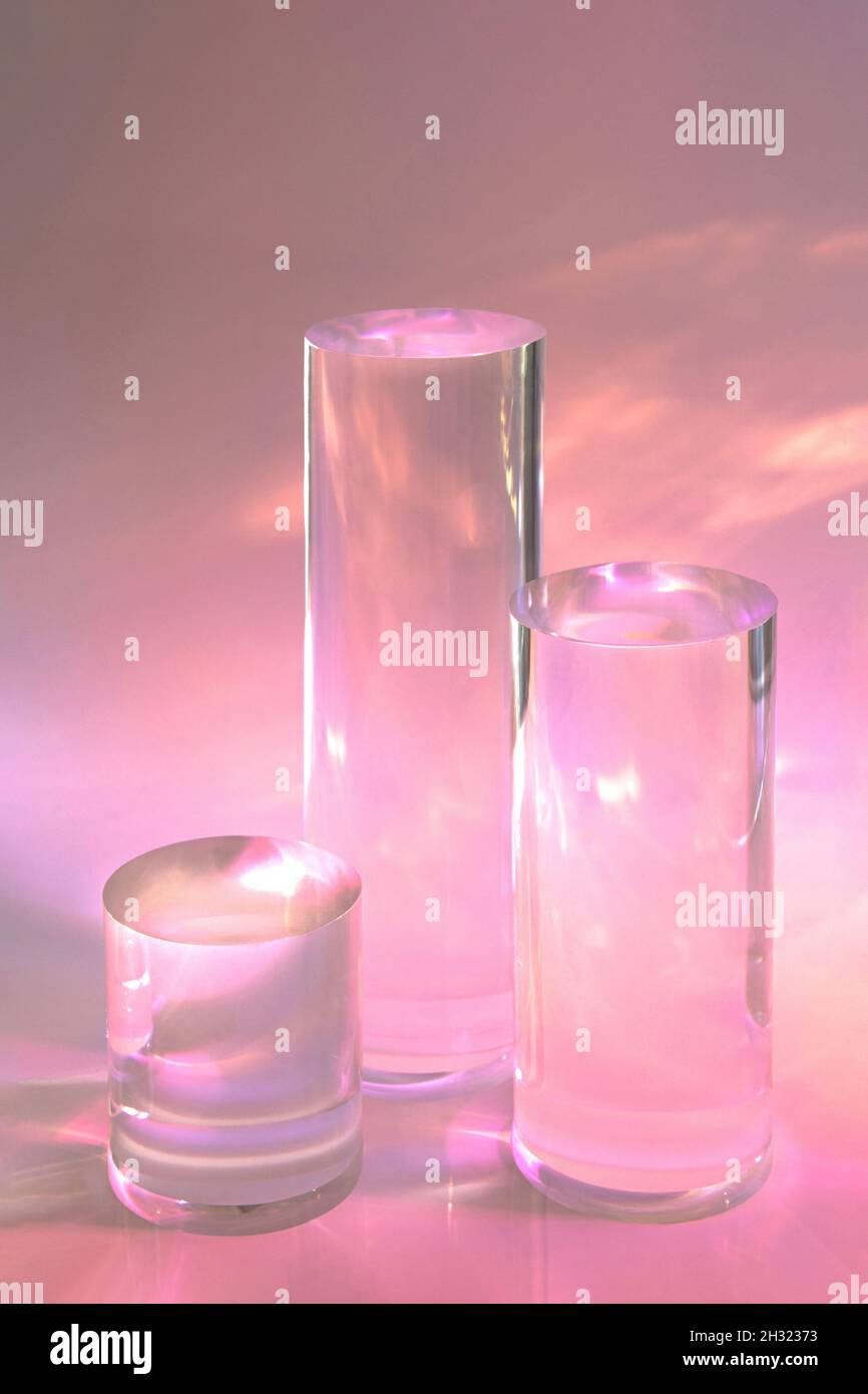 tre podi in vetro chiaro su sfondo rosa pastello Foto Stock