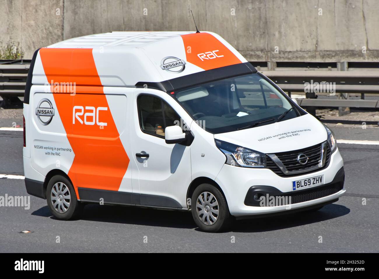 Vista laterale e frontale conducente RAC in Nissan van che guida lungo la strada autostradale del Regno Unito pubblicità una partnership commerciale di lavoro tra due società di automobilismo Foto Stock