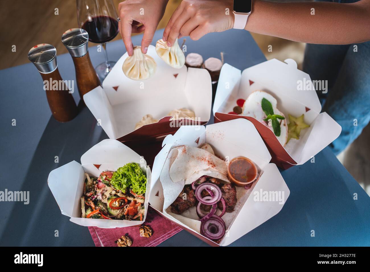 consegna di cibo o scatole di cartone da asporto con insalata, carne, gnocchi o dessert Foto Stock