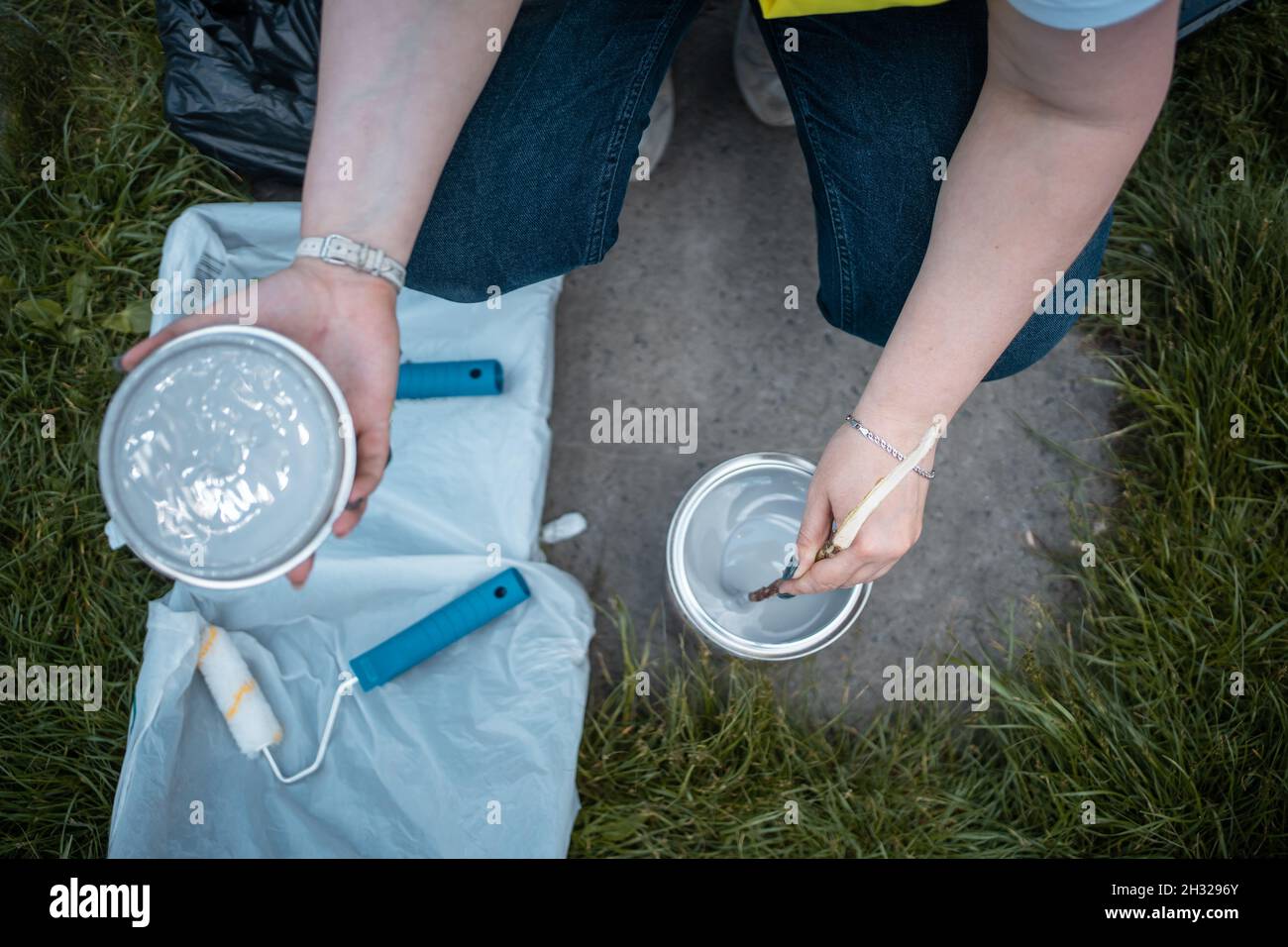 lavoratore che mescola vernice o tintura in secchio prima di verniciare le pareti Foto Stock
