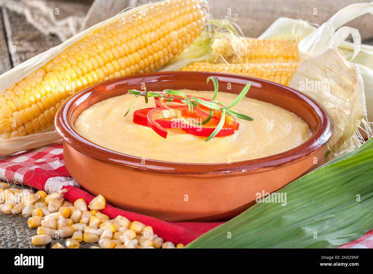 Polenta di mais in ciotola di legno con olio vegetale Foto Stock