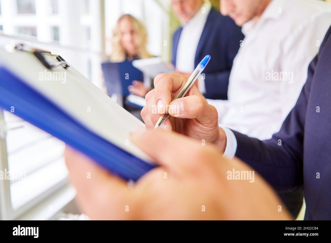 Il personale aziendale con appunti e checklist che pianifica la strategia in officina Foto Stock