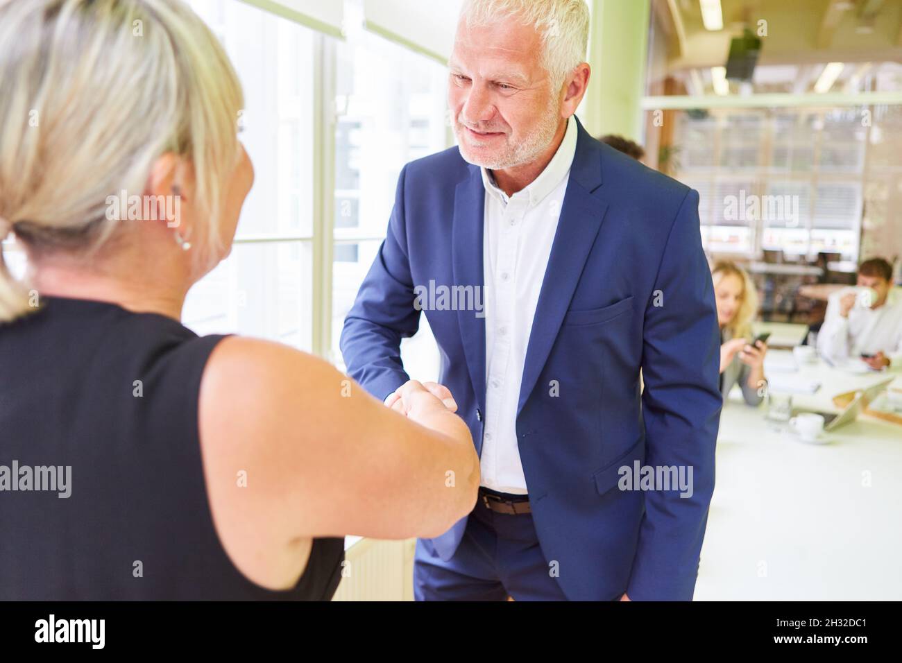 Uomo d'affari anziano durante la stretta di mano per un saluto o le congratulazioni Foto Stock