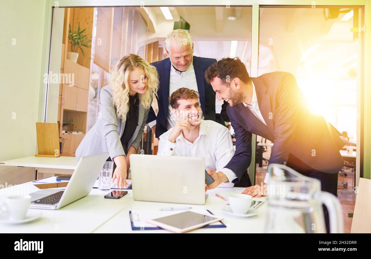 Gruppo felice di persone d'affari al computer come un team in riunione in ufficio Foto Stock