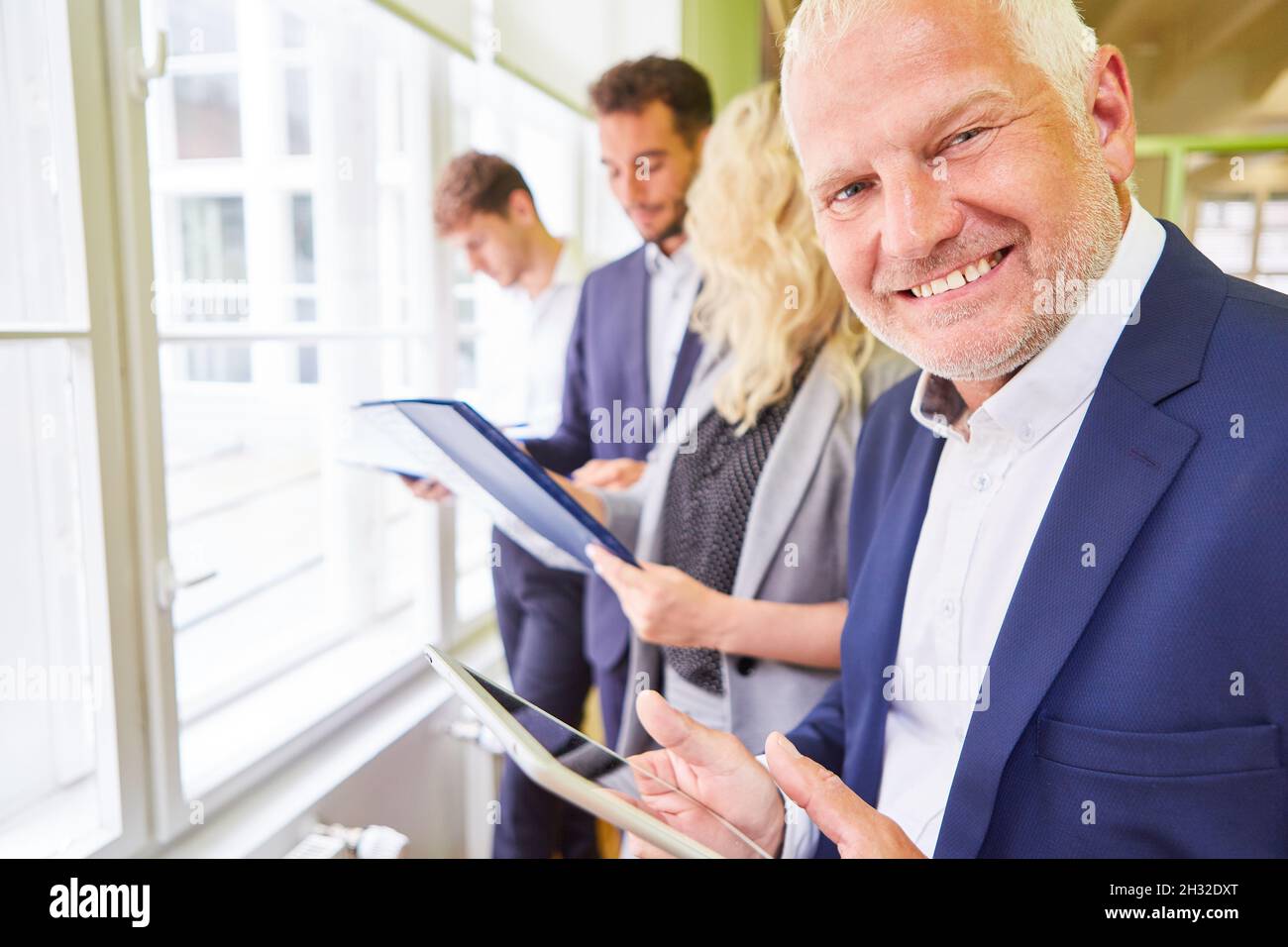 Felice manager e il suo team aziendale in un workshop strategico con appunti Foto Stock