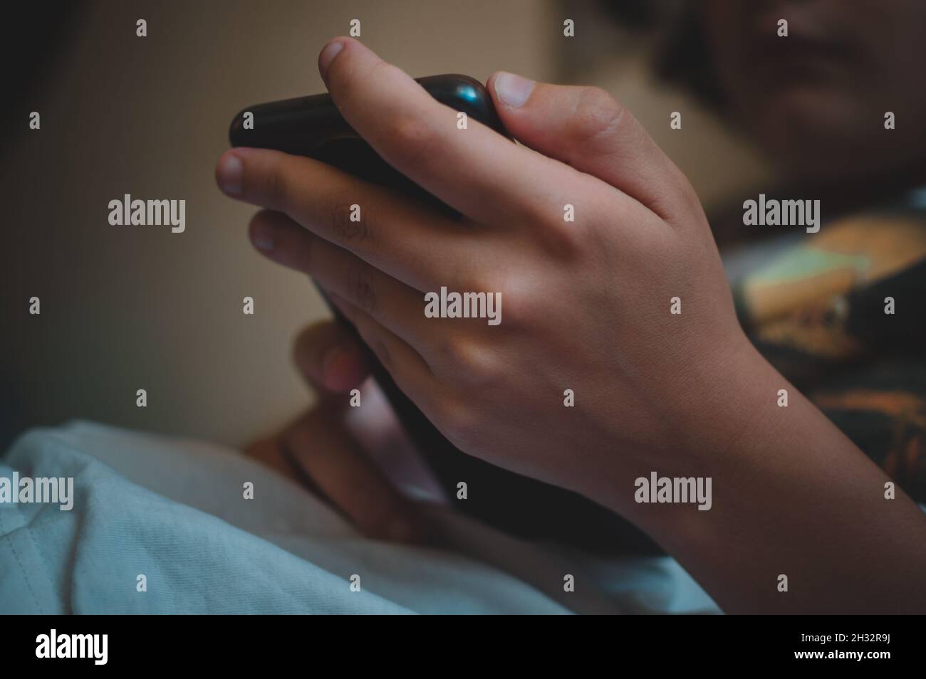 Una ragazza tiene uno smartphone nelle sue mani in primo piano Foto Stock