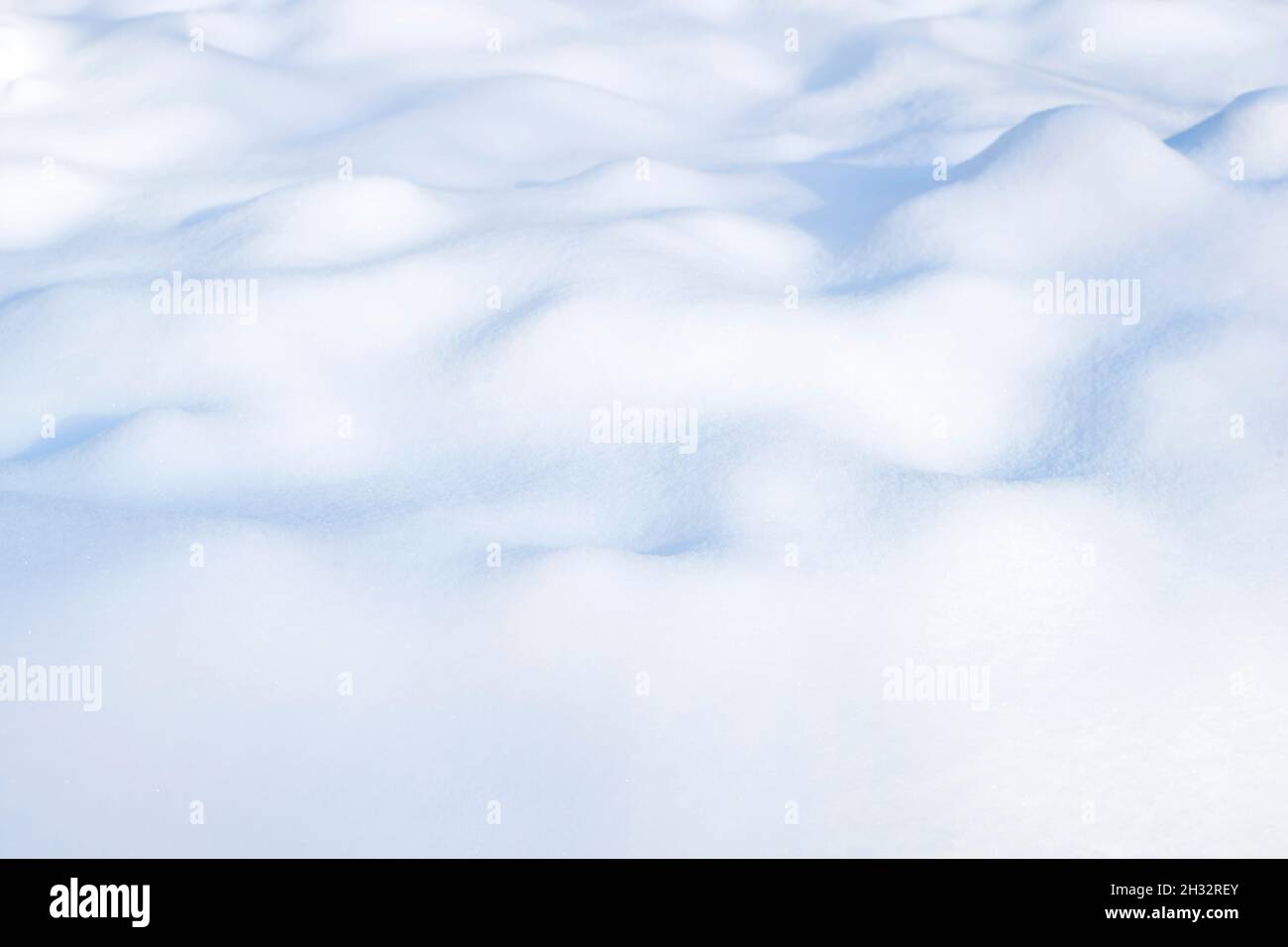 Inverno soleggiato sfondo bianco di neve con sfumature blu di drift Foto Stock