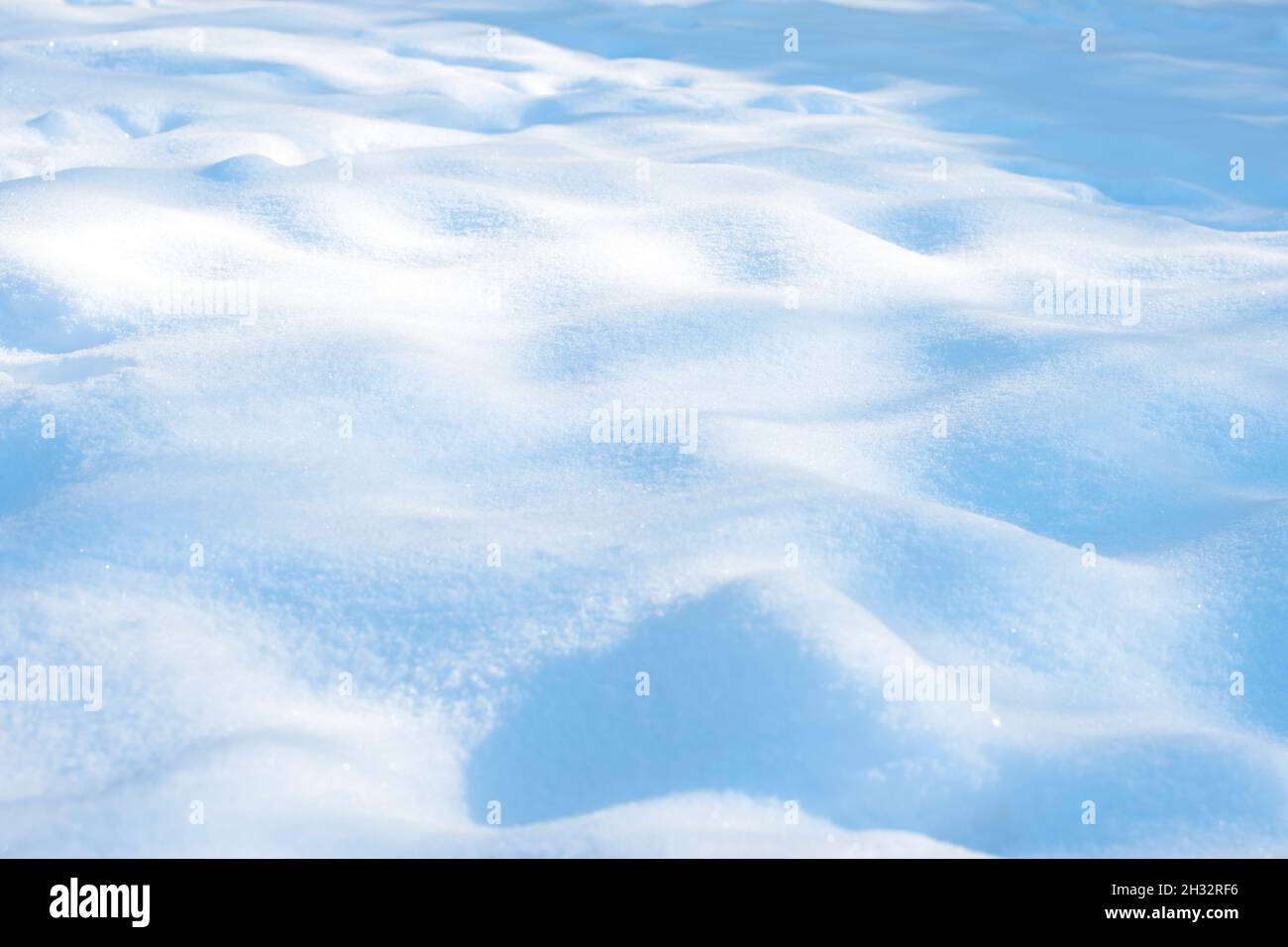 Inverno soleggiato sfondo bianco di neve con sfumature blu di drift Foto Stock