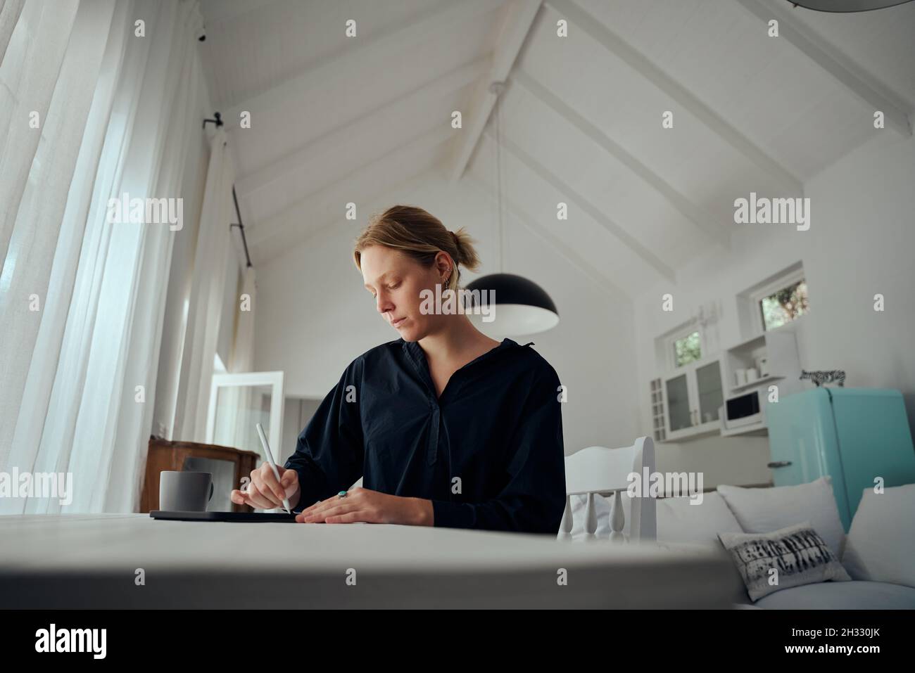 Fashion designer caucasica femminile che lavora in ufficio a casa su tablet digitale Foto Stock