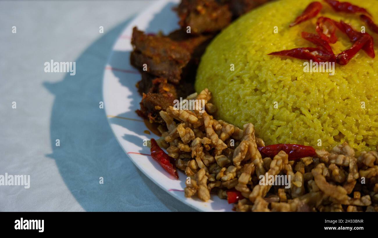 Tradizionale cucina indonesiana 'Nasi Kuning' sul piatto Foto Stock