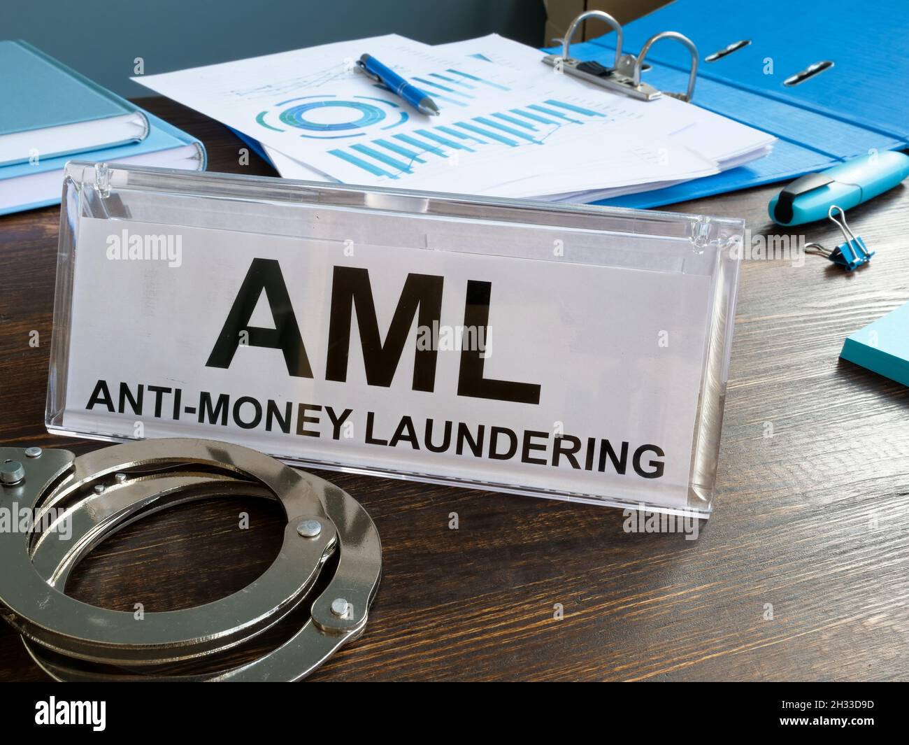 Firma AML antiriciclaggio e manette sulla scrivania. Foto Stock