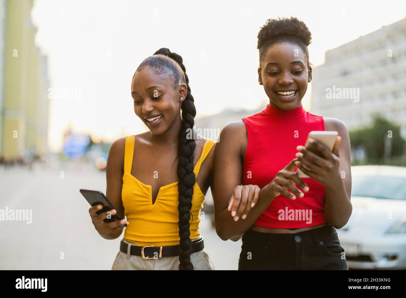 Giovani donne che usano smartphone in città Foto Stock