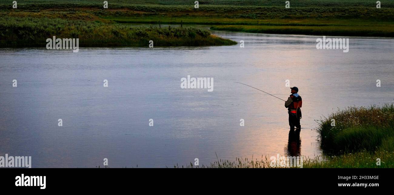 Flyfisherman pescatore a mosca la pesca sul fiume con Tetons in background Foto Stock