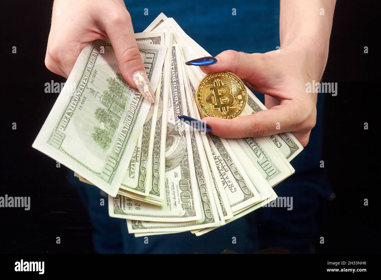 Le mani del woman del primo piano tengono i soldi e il bitcoin. Foto Stock