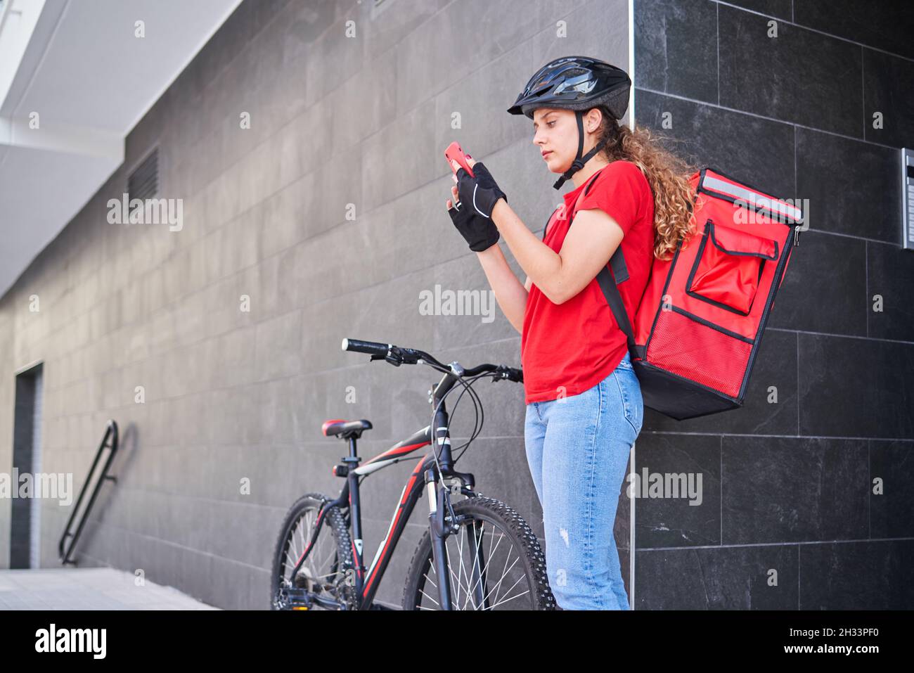 Una ragazza consegna ciclista che suona la campana dell'interfono Foto  stock - Alamy