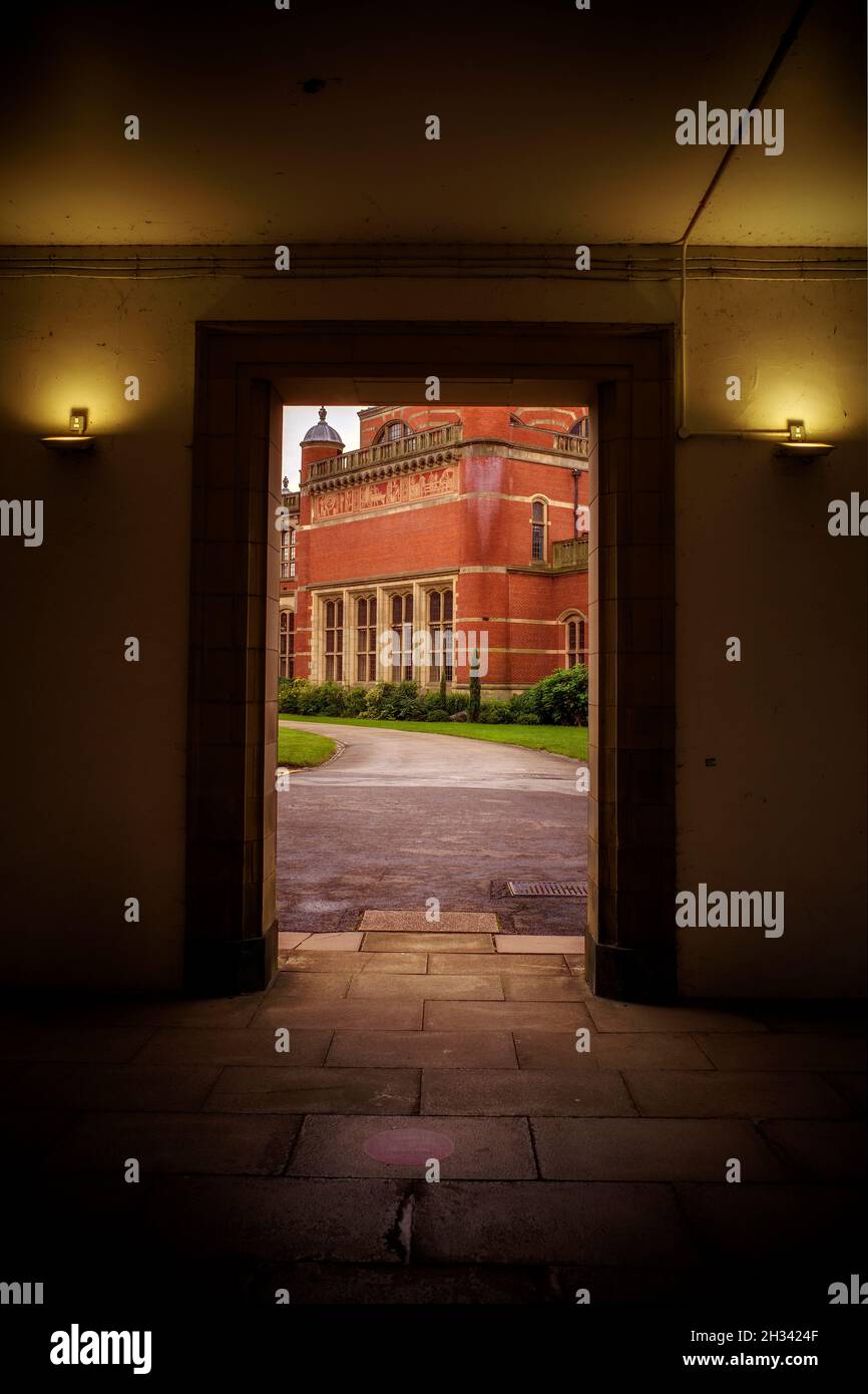 Una vista esterna della Great Hall della Birmingham University da una porta aperta che guarda dall'altra parte del parco. Foto Stock