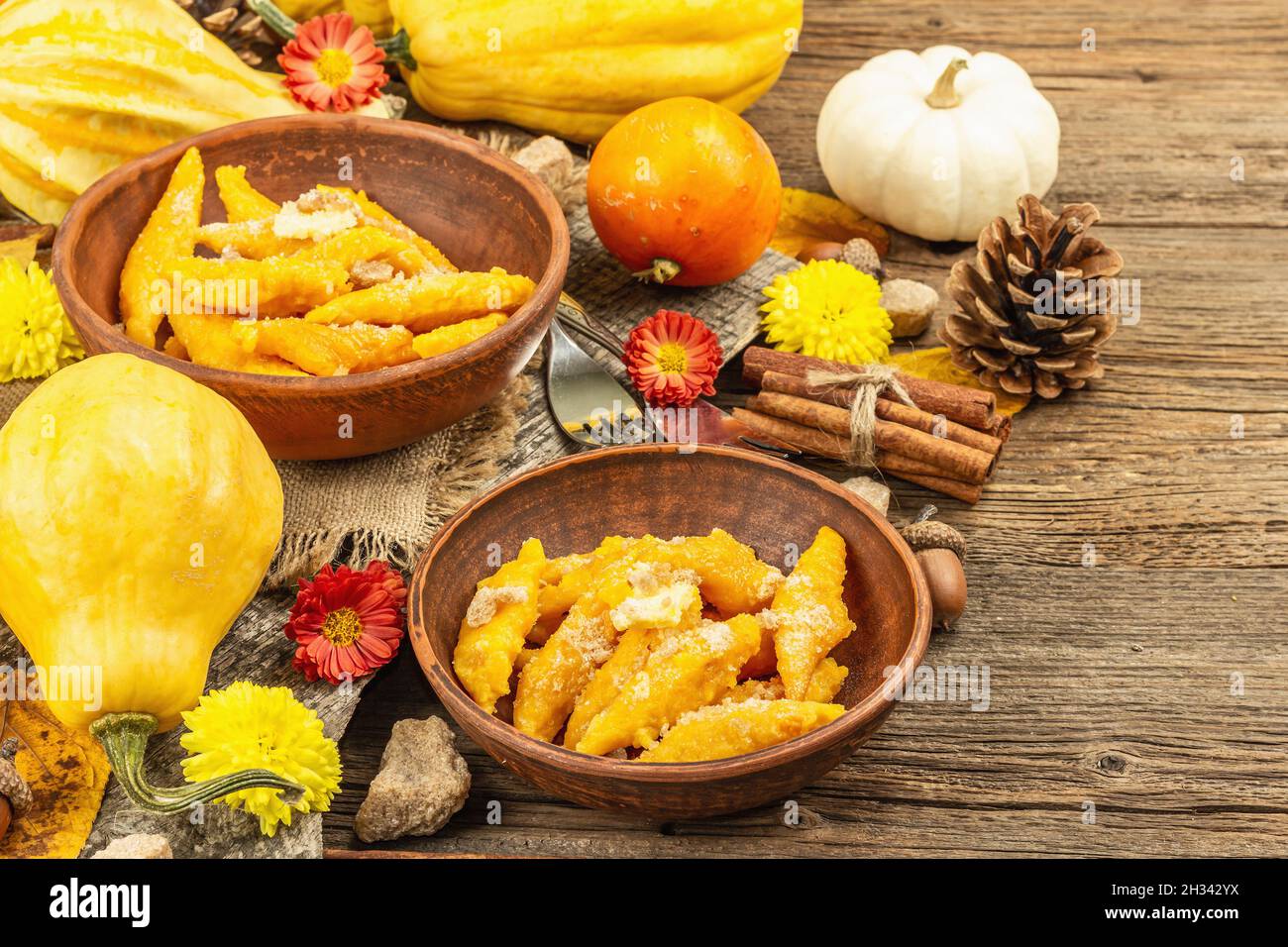 Gnocchi di zucca o gnocchi italiani. Piatto di squash vegetariano sano con formaggio caserario. Decorazioni autunnali con foglie autunnali, coni, zucche intere, fiori Foto Stock